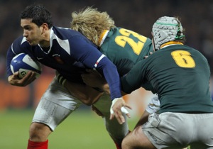 France's Maxime Mermoz, left, is tackled by Wynand Olivier, center, and Heinrich Brussow of South Africa during their international rugby union match in Toulouse, southwestern France, Friday, Nov. 13, 2009. (AP Photo/Christophe Ena)